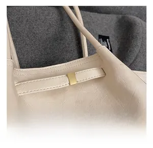Detail of elegant gold metal hardware buckle on creamy white leather shoulder bag