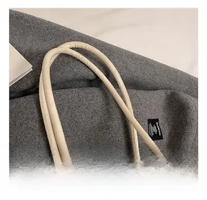 Close-up of cream white tote bag handle showing high-quality stitching and faux leather texture