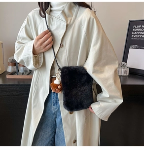Détail du sac bandoulière en fausse fourrure noire avec un joli charm d'ours brun
