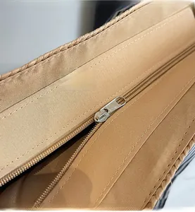 Close-up of durable fabric lining and smooth metal zipper on this woven straw bag