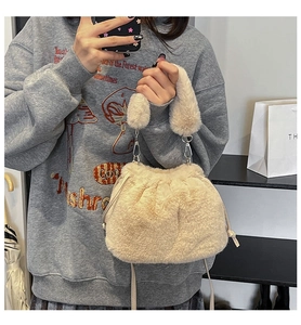 Vue détaillée du sac seau en peluche beige avec cordon et attaches métalliques