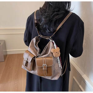 Detailed back view of a retro拼接 canvas and leather backpack worn with a black blazer