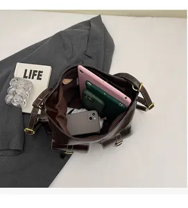 Interior view showing the large capacity of the dark brown leather tote bag with a tablet
