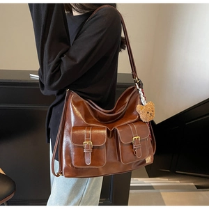Deep brown vintage leather shoulder bag featuring multi-pocket design and bear charm