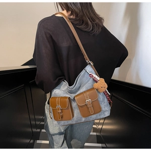 Detail of vintage gray tote bag featuring contrast brown pockets and plush bear charm