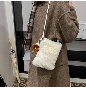 Détail du sac à bandoulière blanc pelucheux avec un charmant singe en peluche marron