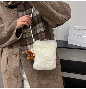 Détail du sac bandoulière en fausse fourrure blanche avec pendentif peluche mignon