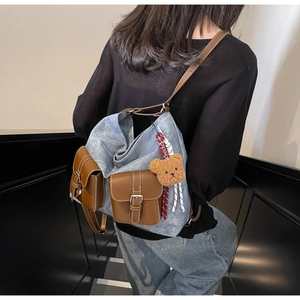 Detail of vintage denim backpack featuring leather pockets and a cute bear keychain