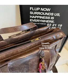 Détail du sac à dos vintage en cuir marron avec fermeture éclair et foulard en soie