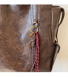 Détail de la texture cuir du sac à dos vintage marron avec breloque clé en bronze vieilli