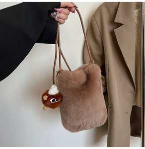 Détail d'un sac bandoulière en fausse fourrure marron avec un joli pendentif peluche