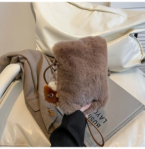 Détail du sac bandoulière en peluche marron avec un joli porte-clés en forme d'ours