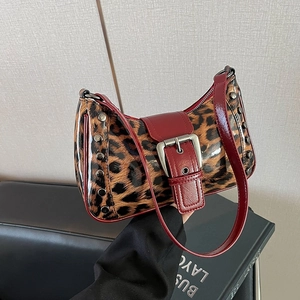 Detalle del bolso de leopardo con ribete rojo y gran hebilla plateada de metal