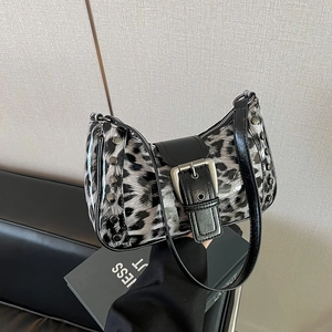 Detalle del bolso de leopardo con remaches plateados y correa con hebilla de cuero negro