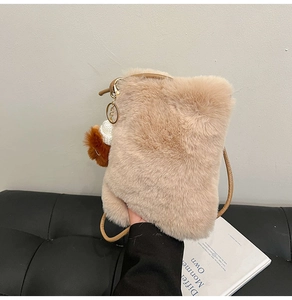 Détail d'un sac bandoulière en peluche beige avec fausse fourrure et décorations dorées