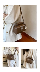 Detail of brown litchi pattern leather Boston bag with silver ball charm and shoulder strap