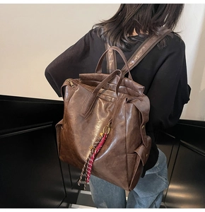 Détail de la vue arrière d'un sac à dos rétro en cuir marron avec charme tissé