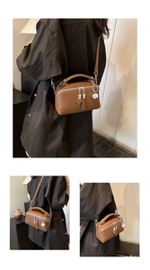 Close-up of caramel brown box-shaped bag featuring pebble leather and silver charm