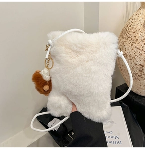Détail du sac bandoulière en peluche blanche avec breloque ours brun et boucles dorées