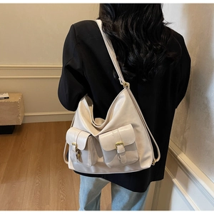 Detail of soft beige PU leather texture and retro gold buckles on large tote bag