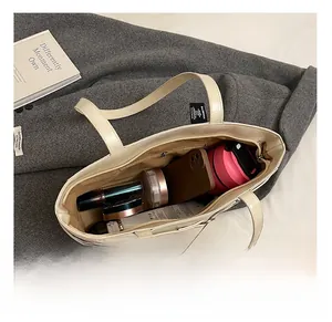 Draufsicht auf das Innere der cremeweißen Ledertasche mit großem Fassungsvermögen und Reißverschluss