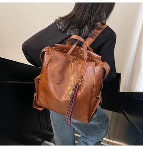 Vue détaillée d'un sac à dos vintage en cuir marron avec charme de raquette sur un modèle