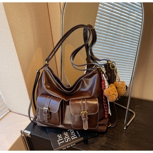 Detail of dark brown vintage tote bag with functional double pockets and gold buckles