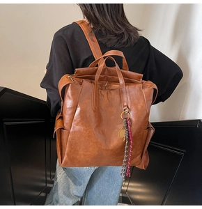 Vue de dos d'un mannequin portant un sac à dos vintage en cuir marron avec pendentif