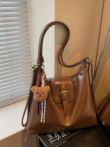 Retro brown leather tote bag for women featuring vintage metal buckle and plush bear charm