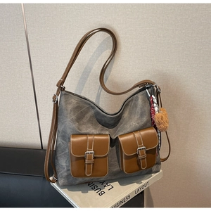 Close-up of vintage canvas tote bag with leather front pockets and plush bear charm