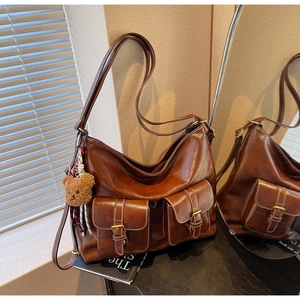 Detail of vintage brown tote bag featuring multi-pocket design and white contrast stitching