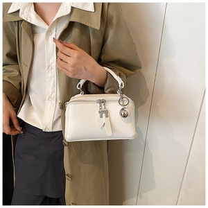 Detail of white lychee leather handbag with double zipper and silver metal ball charm