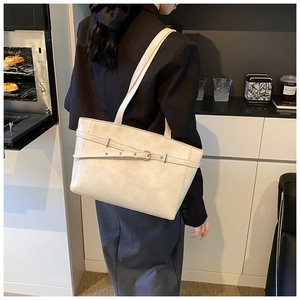 Detailaufnahme der cremefarbenen Leder-Tote-Bag mit silberner Schnalle und feiner Struktur