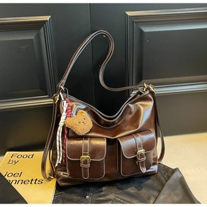 Detail of vintage dark brown tote bag with multi-pocket design and contrast stitching