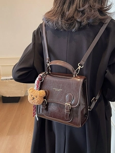 Vintage brown leather backpack with glossy finish and cute bear charm for women