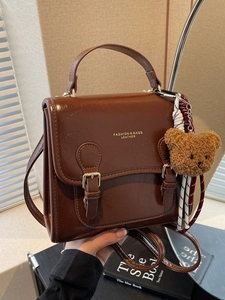 Retro brown leather handbag with plush bear pendant and adjustable long strap for women