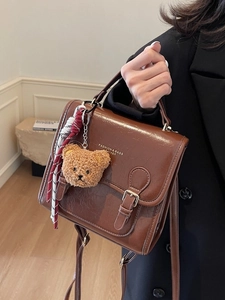 Vintage brown leather crossbody bag with metal buckle and plush bear charm for daily fashion