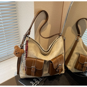 Detailed macro of vintage canvas tote with brown leather pockets and plush bear charm decor