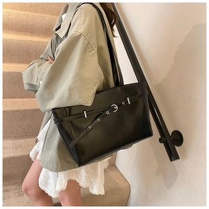 Detail der schwarzen Shopper-Tasche mit Lederstruktur und silberner Gürtelschnalle