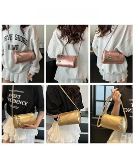 Detail view of cylinder crossbody bag with heart pendant in rose gold and bright gold