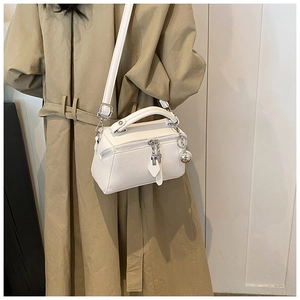 Close-up of white lychee leather texture with dual zippers and silver metal charm