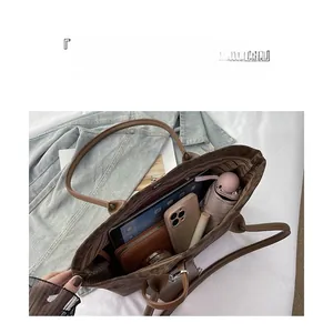 Macro view of leopard print suede tote bag interior with multiple essential items