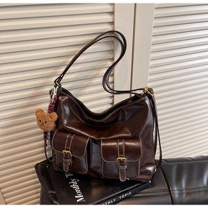 Detail of dark brown tote bag featuring multi-pockets with white contrast stitching