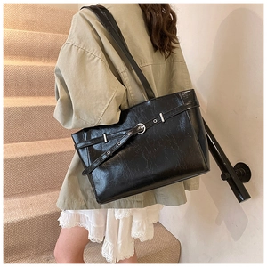 Detailansicht der schwarzen Tote Bag aus Glanzleder mit Schnallen-Design und Schulter-Passform
