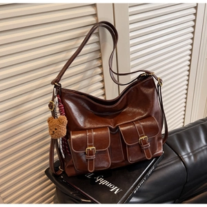 Detail of dark brown faux leather tote with dual front pockets and white contrast stitching