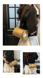 Detailed view of a gold barrel bag featuring a metallic finish and heart chain charm