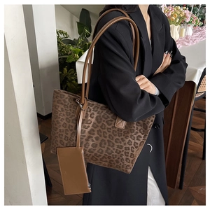 Leopard print tote bag with small purse accessory shown on model in black blazer