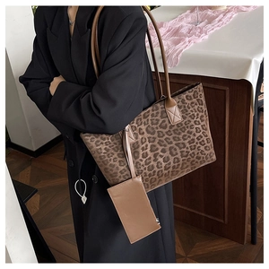 Detail of a large leopard print suede tote bag with a matching small zipper pouch attached