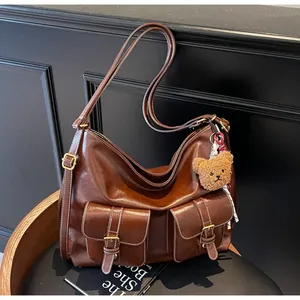 Detailed shot of dark brown faux leather tote with cargo pockets and bear charm