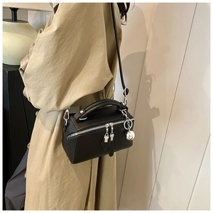 Detail of black pebbled leather Boston bag with silver zippers and sphere pendant charm